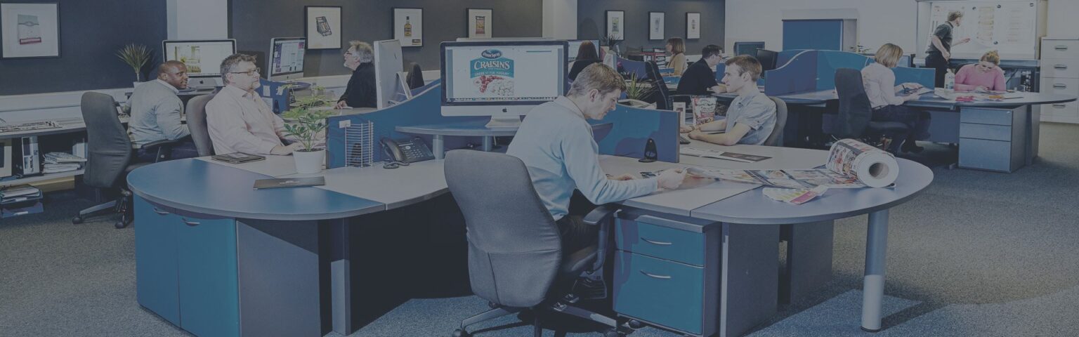 Image of people in an office, looking at labels and computer screen