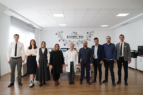 A group of people standing in their office.