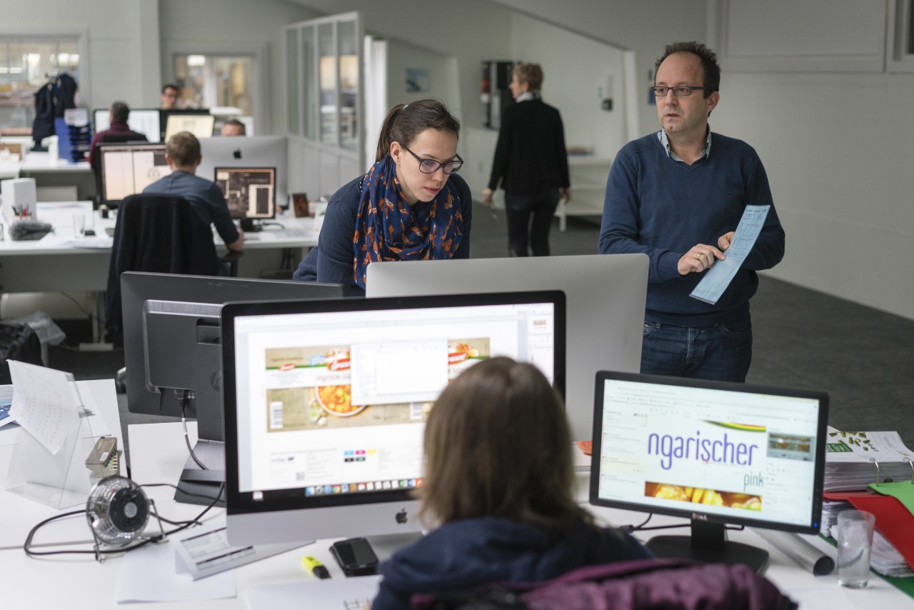 photo of people in an office gathered around a computer